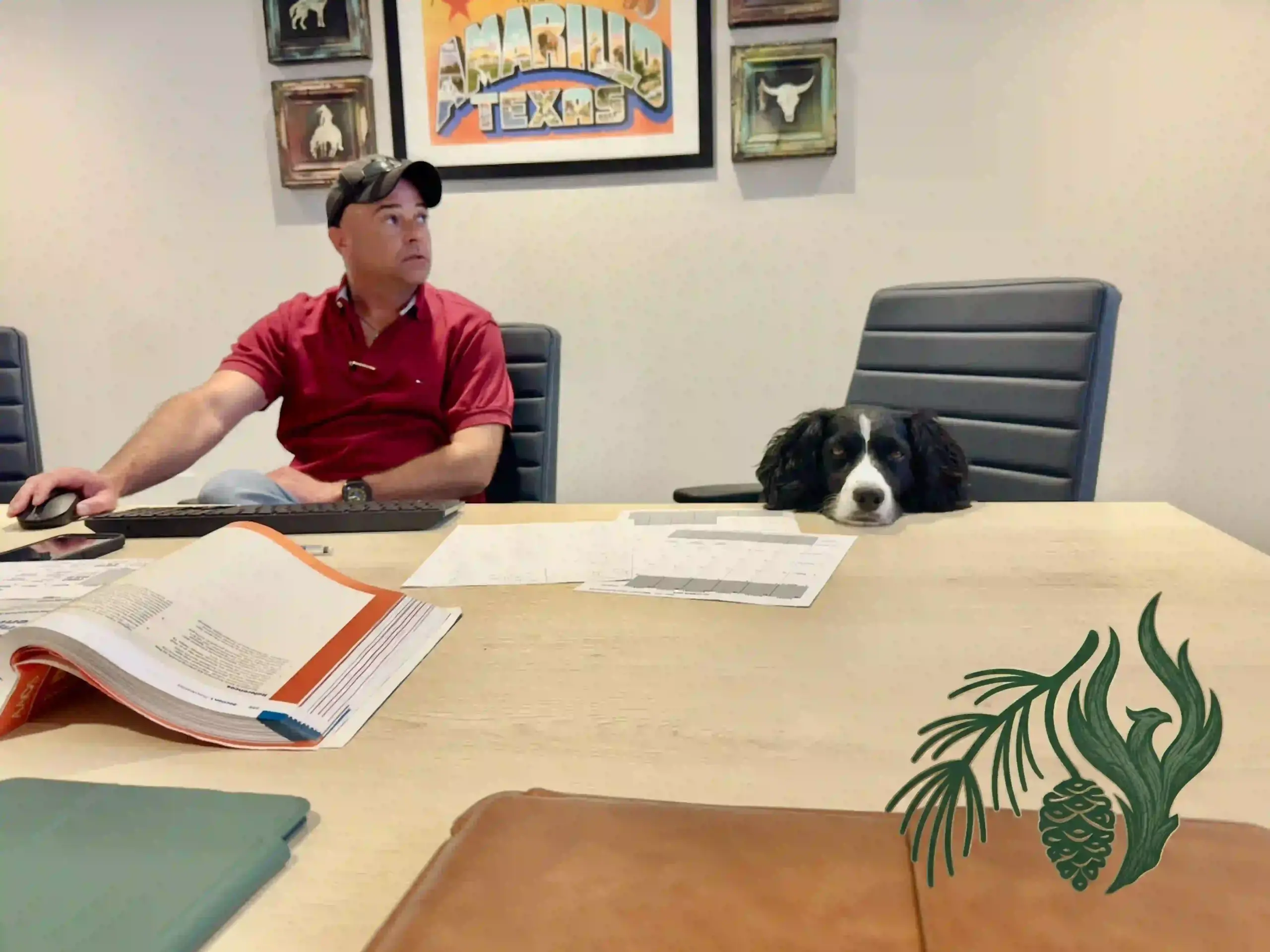 An open Emergency Medical Services textbook sits on a conference room table in front of a service dog during a curriculum design session.